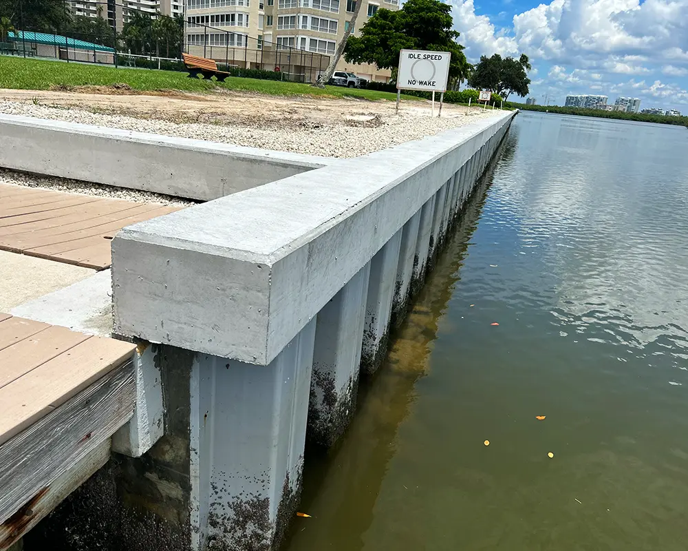 Top 5 Questions to Ask Before Hiring a Seawall Contractor in Florida. Featuring a photo of a complete seawall installation in Naples, as performed by Overall Outdoor Services.
