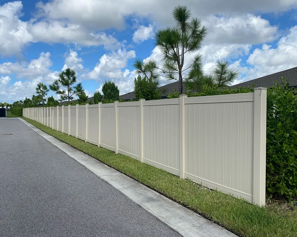 Fence Types: Privacy vs. Price in Southwest Florida. Featuring a white vinyl fence blocking a homeowner's backyard from the street.